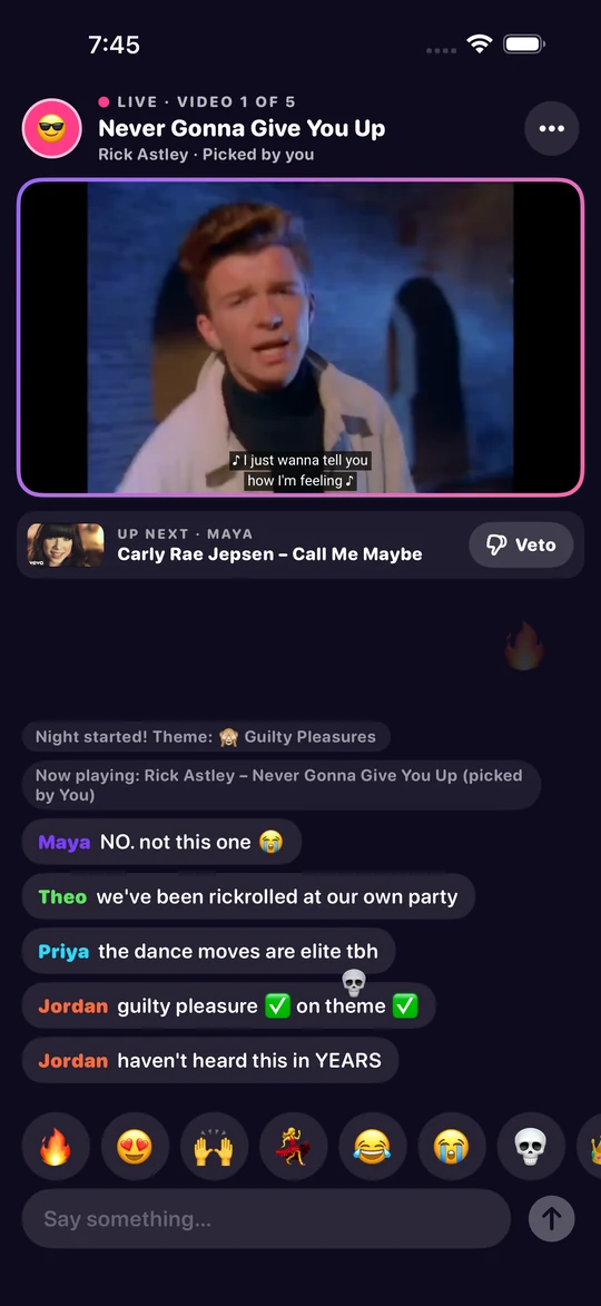 A music video playing in the app with a live chat below it and a row of emoji reaction buttons.